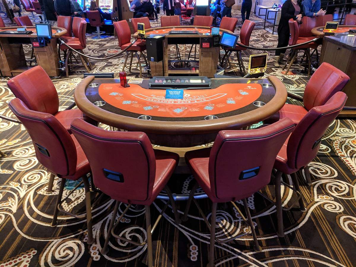 A blackjack table between deals, chairs drawn up around the felt