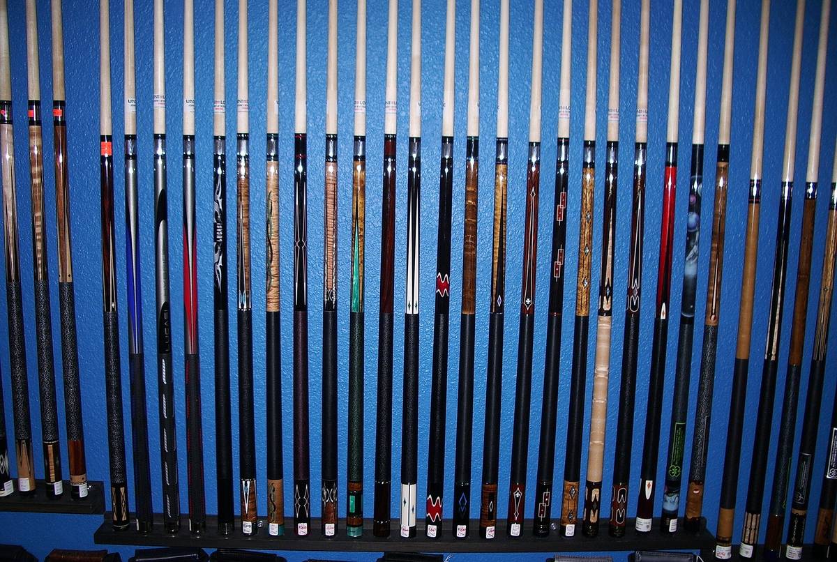Two-piece pool cues laid out side by side, butts and shafts apart