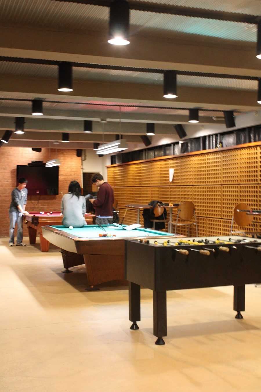 A basement game room sharing space between a pool table and a foosball table