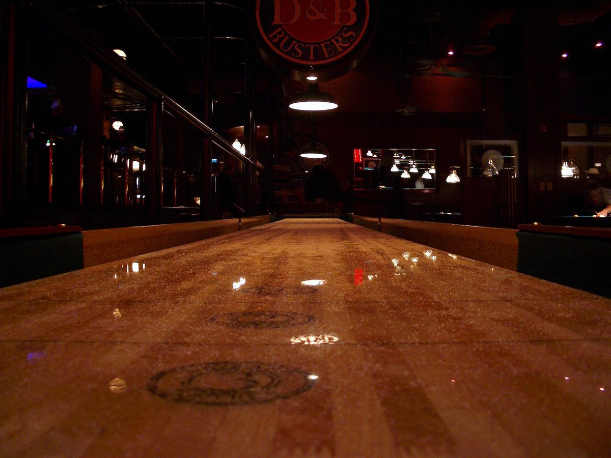The length of a table shuffleboard, silica spread over the playing surface