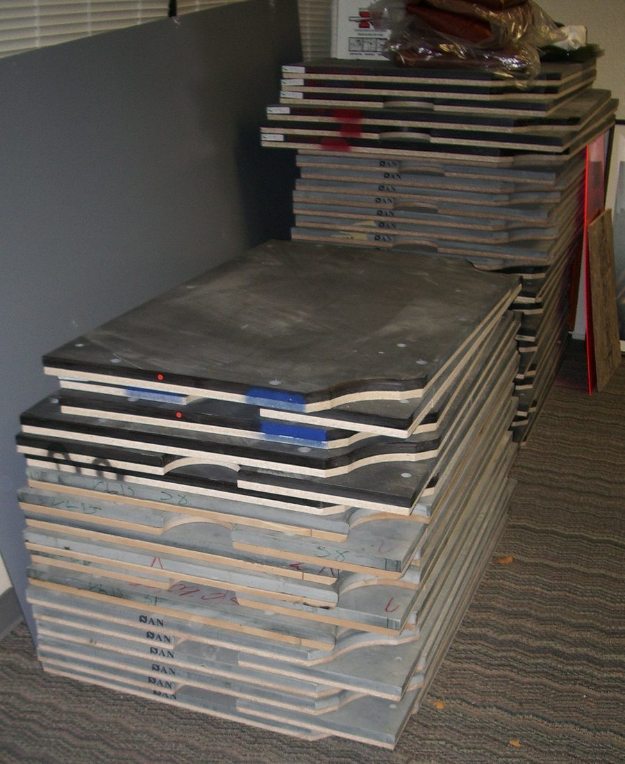 Plywood-backed bed slates stacked in a workshop before assembly