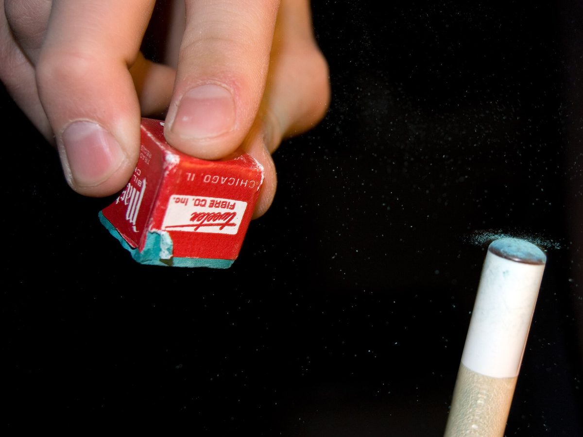 A cube of chalk beside a cue tip and ferrule
